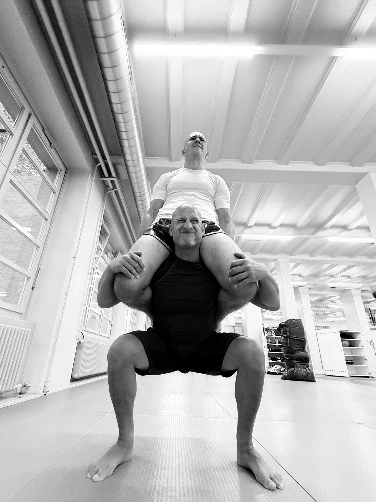 Kniebeugen mit Trainingspartner auf den Schultern